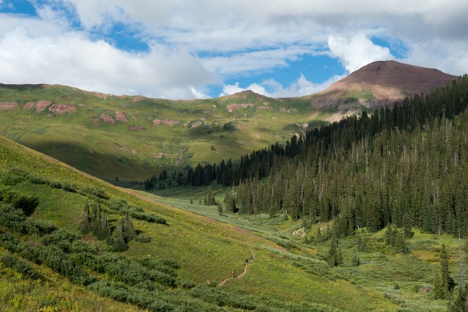 A hiking trail between Aspen and Crested Butte through a lush green valley.